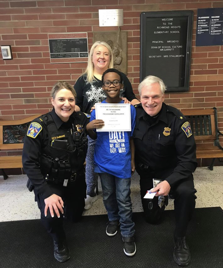 Lt. Denise DeBiase and Chief Tom Wetzel congratulate Kalib Walton, 10, and teacher Meredith Connorton at Richmond Heights Elementary School. Photo courtesy of Richmond Heights Police Department