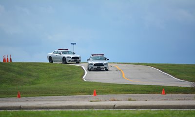 Police cars navigate OPOTA's driving track.